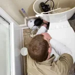 Technician repairing a toilet