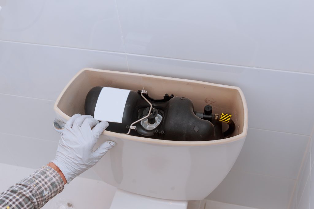 plumber repairing toilet tank in bathroom plumbing 2022 08 01 04 00 19 utc